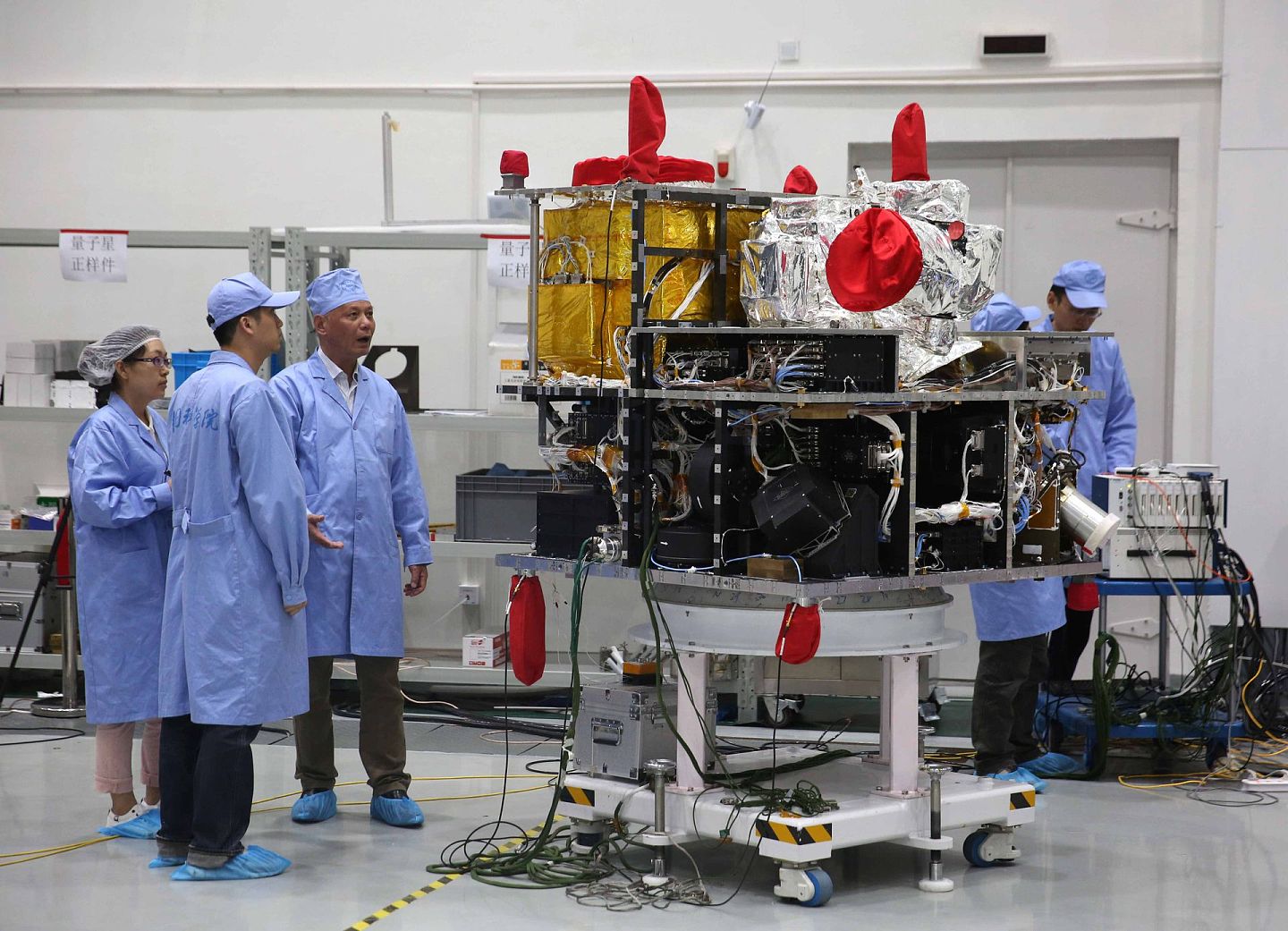 2016年5月25日，在中国科学院上海微小卫星工程中心，量子科学实验卫星副总设计师周依林（左三）与工作人员在量子卫星旁忙碌。 （新华社）