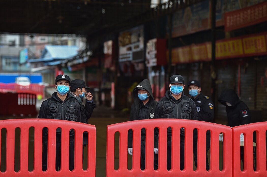 1月24日，在武汉华鲜市场外站岗的警察和保安。当局正忙于控制疫情的混乱局面，而在很短的一段时间里，中国严格的审查机器松懈了。