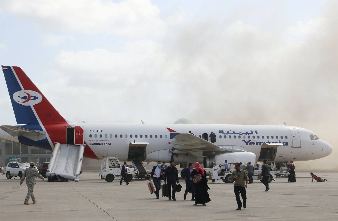 也门亚丁机场爆炸：图为12月30日发生爆炸后，飞机乘客纷纷离开。 从相中可见，救生滑梯已打开。 （Reuters）