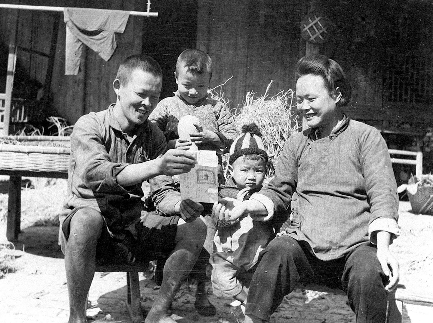 1950年浙江省嘉兴镇东乡农民土改胜利完成后，农民高彩官和家人一起看领到的土地证。 （新华社）