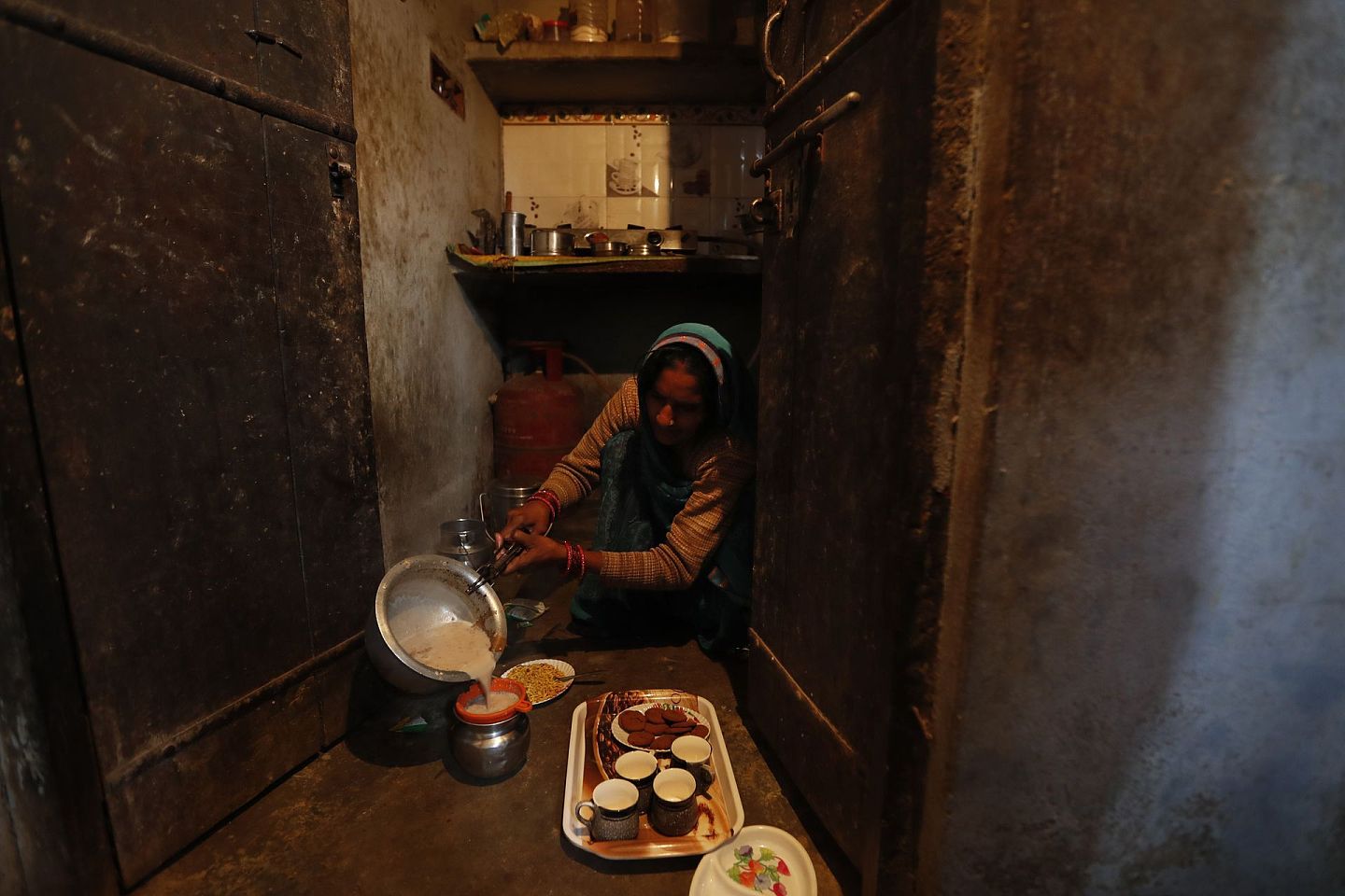 2020年12月19日星期六，印度勒克瑙以南180公里(112英里)的法特普尔地区，农民拉姆·辛格·帕特尔的妻子坎蒂·德维在家里为家人准备早茶。（AP）