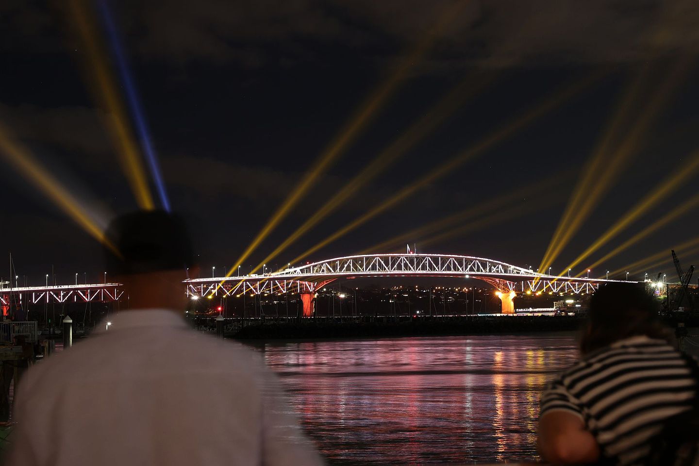 图为2021年1月1日新西兰奥克兰的民众在观看港湾大桥的灯光表演。（Getty）
