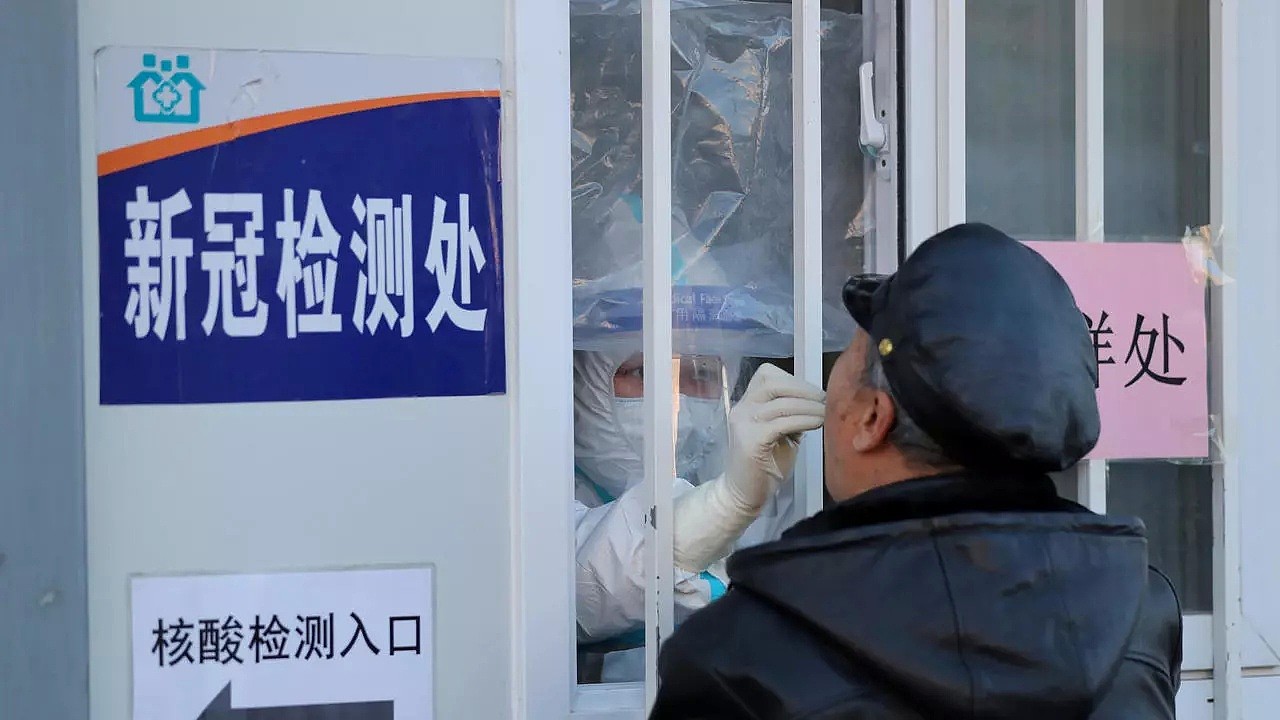 中国辽宁省沈阳市爆发一连串本土病例，全市开始大规模排查。图为一名医务人员从一名男子那里收集拭子进行核酸检测。
