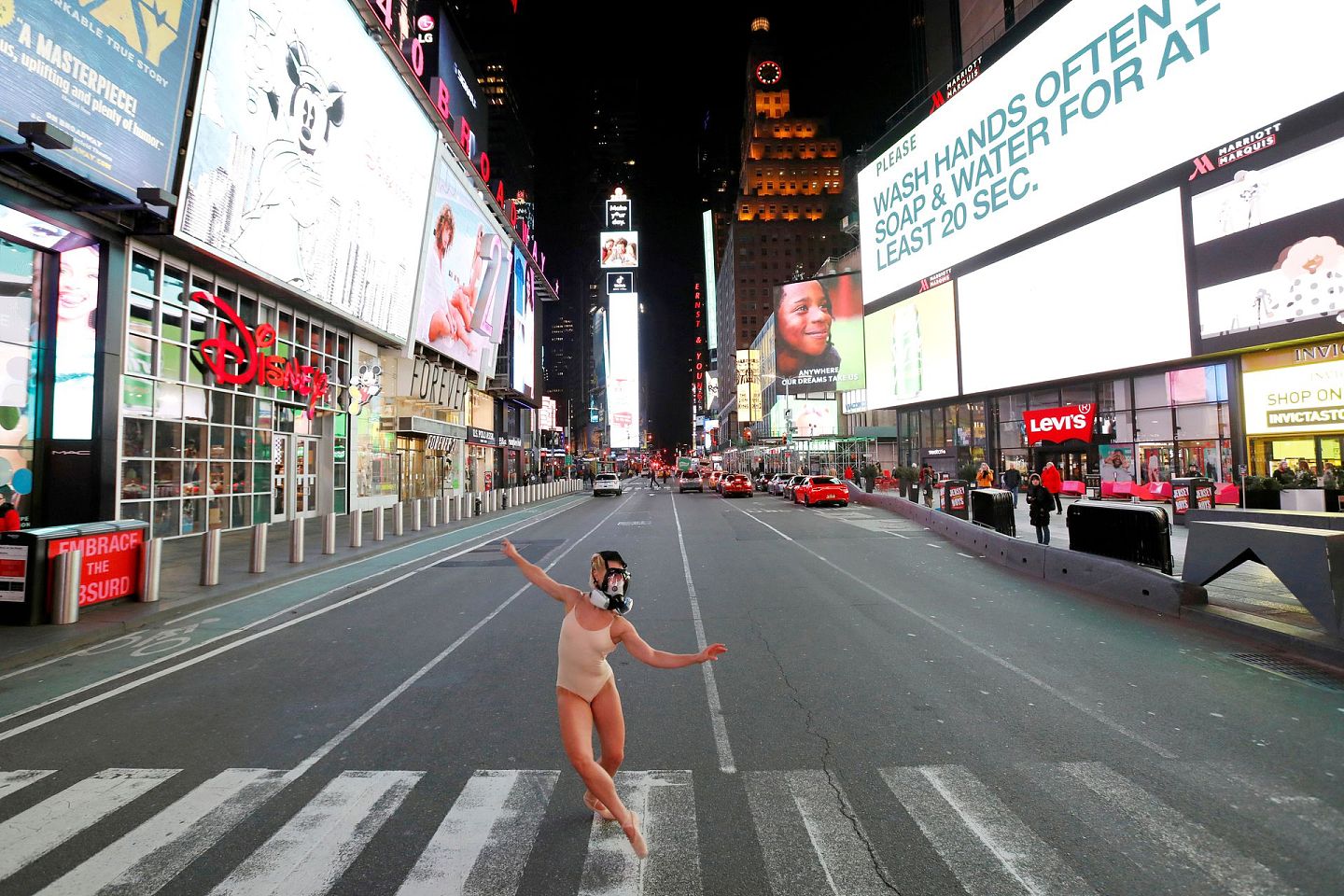 2020年3月18日，在新冠疫情爆发期间，纽约芭蕾舞演员兼演员阿什利·蒙塔古（Ashlee Montague）戴着口罩在时代广场跳舞。（Reuters）