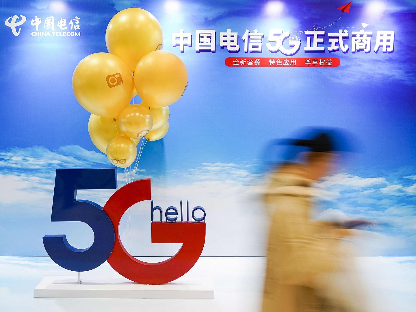 2019年10月31日，在中国电信北京公司朝阳门营业厅，一名消费者走过中国电信5G正式商用的广告展板。（视觉中国）