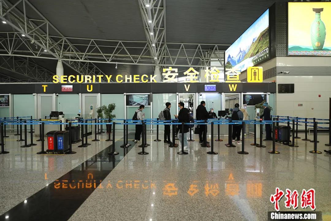 机场工作人员提醒旅客保持一米距离。毓秀斋 摄