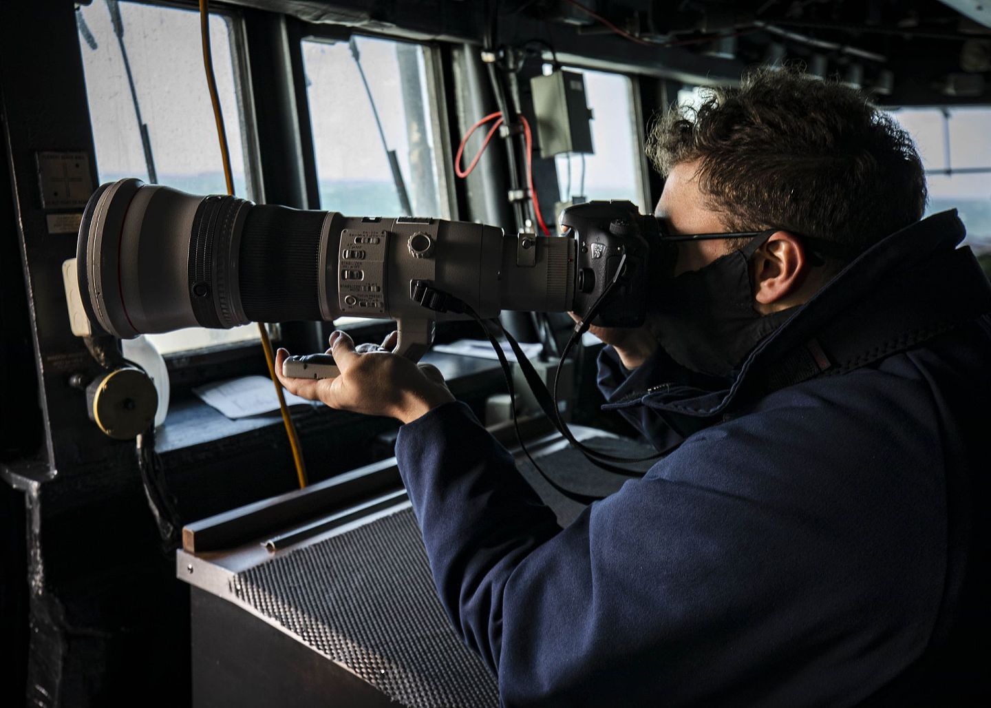 “麦凯恩”号上的一名船员正在用望远镜观察海面状况。（美国第七舰队官网）