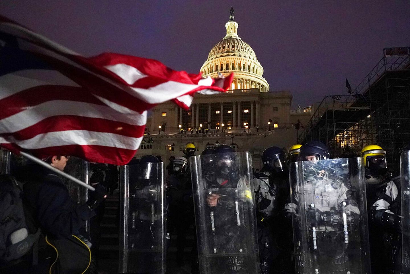 2021年1月6日，特朗普支持者冲击华盛顿的国会大厦，在经过一天的抗议后，警察站在国会山外维持治安。（AP）