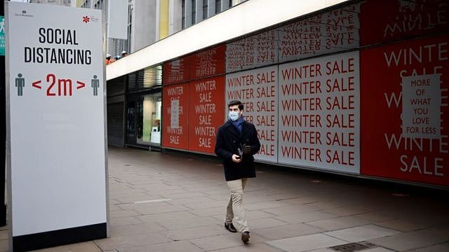 A man walking past closed shops