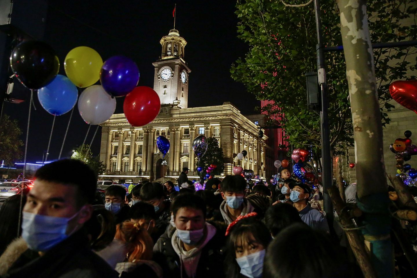 2020年12月31日，在曾经的疫情爆发中心，中国武汉民众聚集在一起，迎接新年的到来。很多民众拿着五颜六色的气球，烘托出喜庆的气氛。（Reuters）