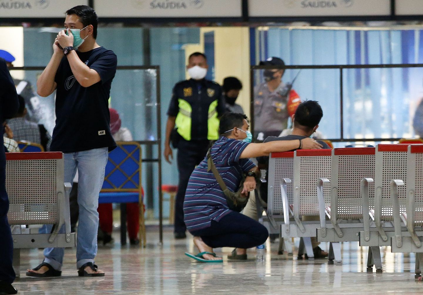 印尼三佛齐空难：图为1月9日，印尼唐格朗的苏加诺—哈达国际机场的临时危机中心内，有人坐在椅上，另有一人蹲在他身旁，看似在予以安慰。（Reuters）