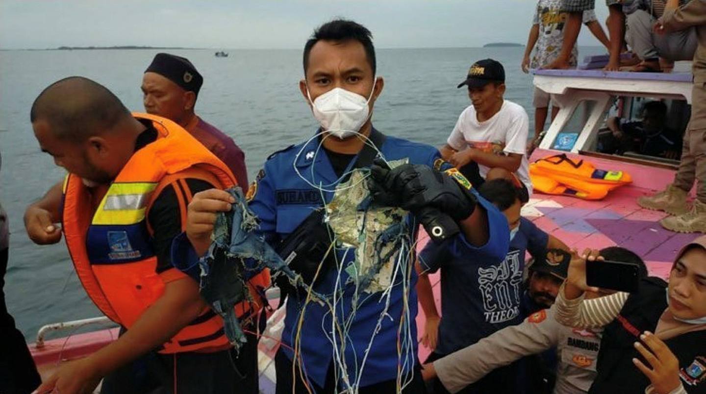 印尼三佛齐空难：图为1月9日在Twitter上流传的照片、显示渔民手持疑似是印尼三佛齐航空公司失事客机的残骸。 (Reuters)