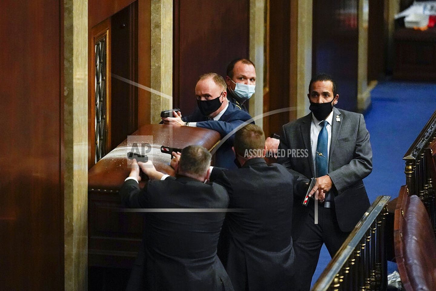 警察持枪注视著试图闯入美国国会大厦众议院的抗议者。 （美联社）