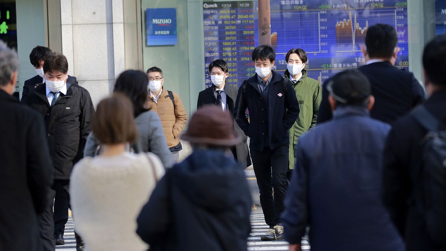 日本以及全球疫情日渐严重，外界质疑东京奥运会能否举办。图为2020年12月24日，东京街头的行人佩戴口罩。（AP）