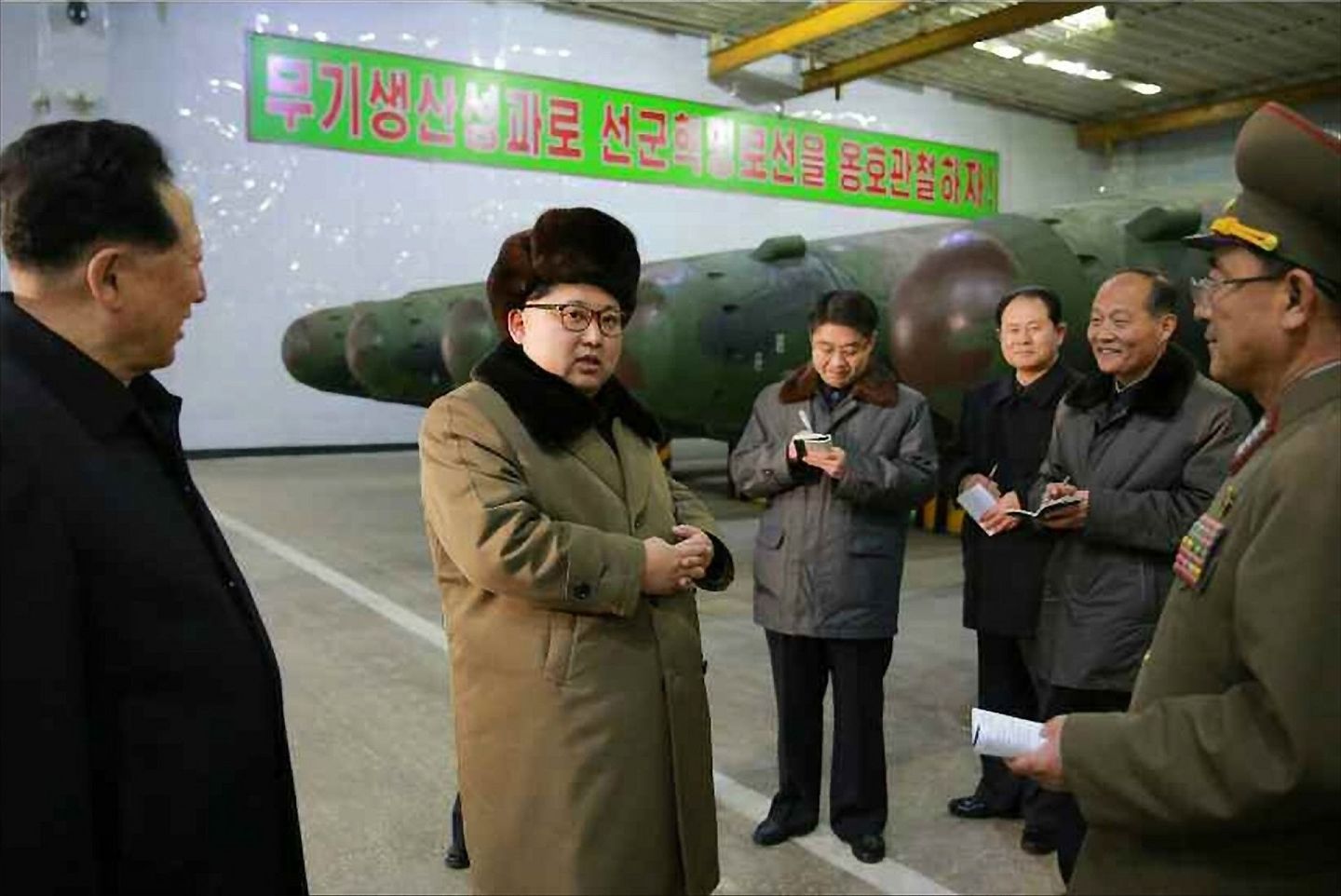 2016年3月9日，朝鲜最高领导人金正恩（左二）在会见核武器研发领域的科学家和技术人员时表示，朝鲜成功实现核弹头小型化、标准化和系列化，便于弹道火箭携带。 金正恩高度评价全新的朝鲜核弹头技术并表示，朝鲜的核科学家和技术人员在国防科学研究方面取得了巨大成果。（AFP）