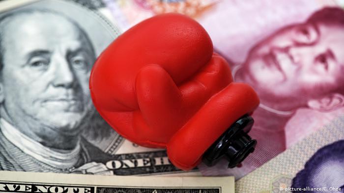 Boxhandschuh auf Dollarnoten und chinesischen Renminbi