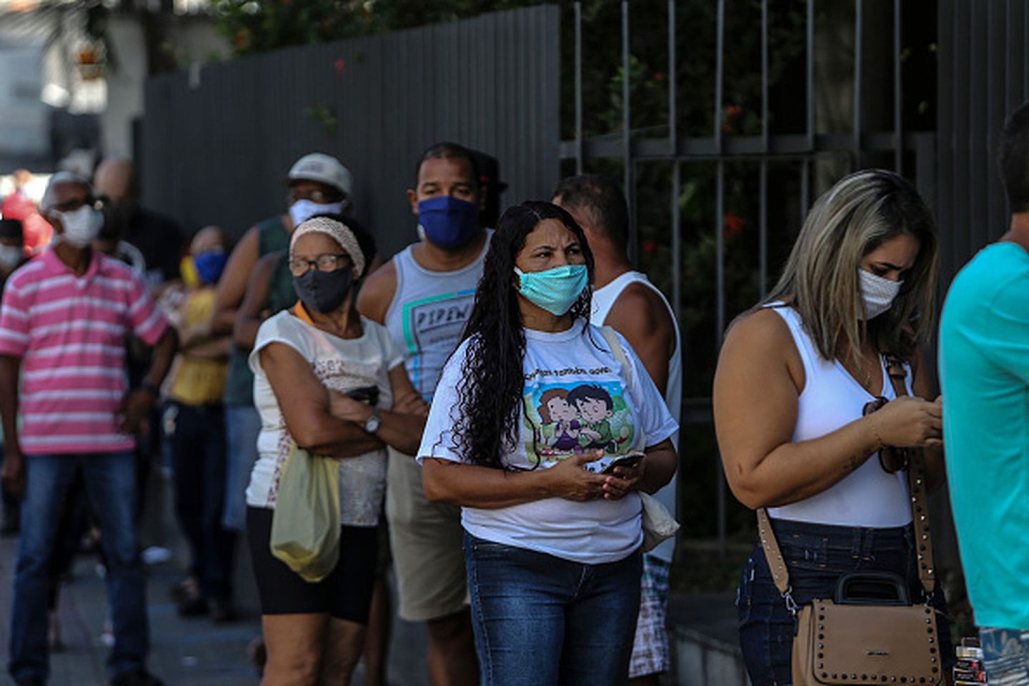 肆意蔓延的疫情让许多巴西民众的生活陷入困顿之中。图为2020年5月5日，巴西圣甘卡洛市的当地居民在市中心的联邦经济银行外排队领取由联邦政府发放的财政补贴。（Getty Images）