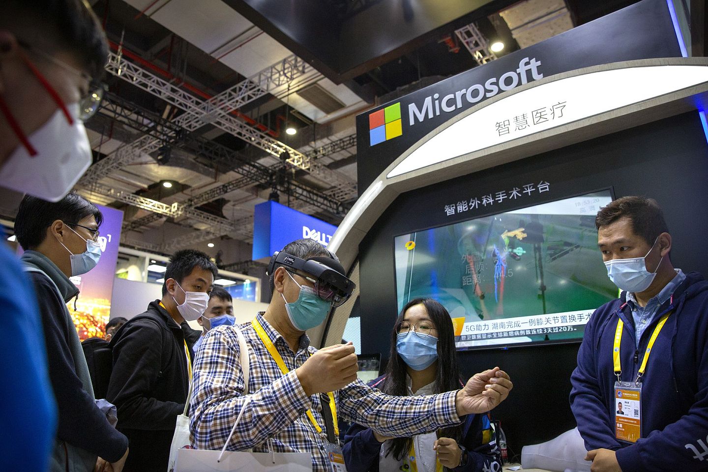2020年11月5日，中国国际进口博览会在上海开幕，一名戴着口罩的参观者使用增强现实眼镜进行参观。（AP）