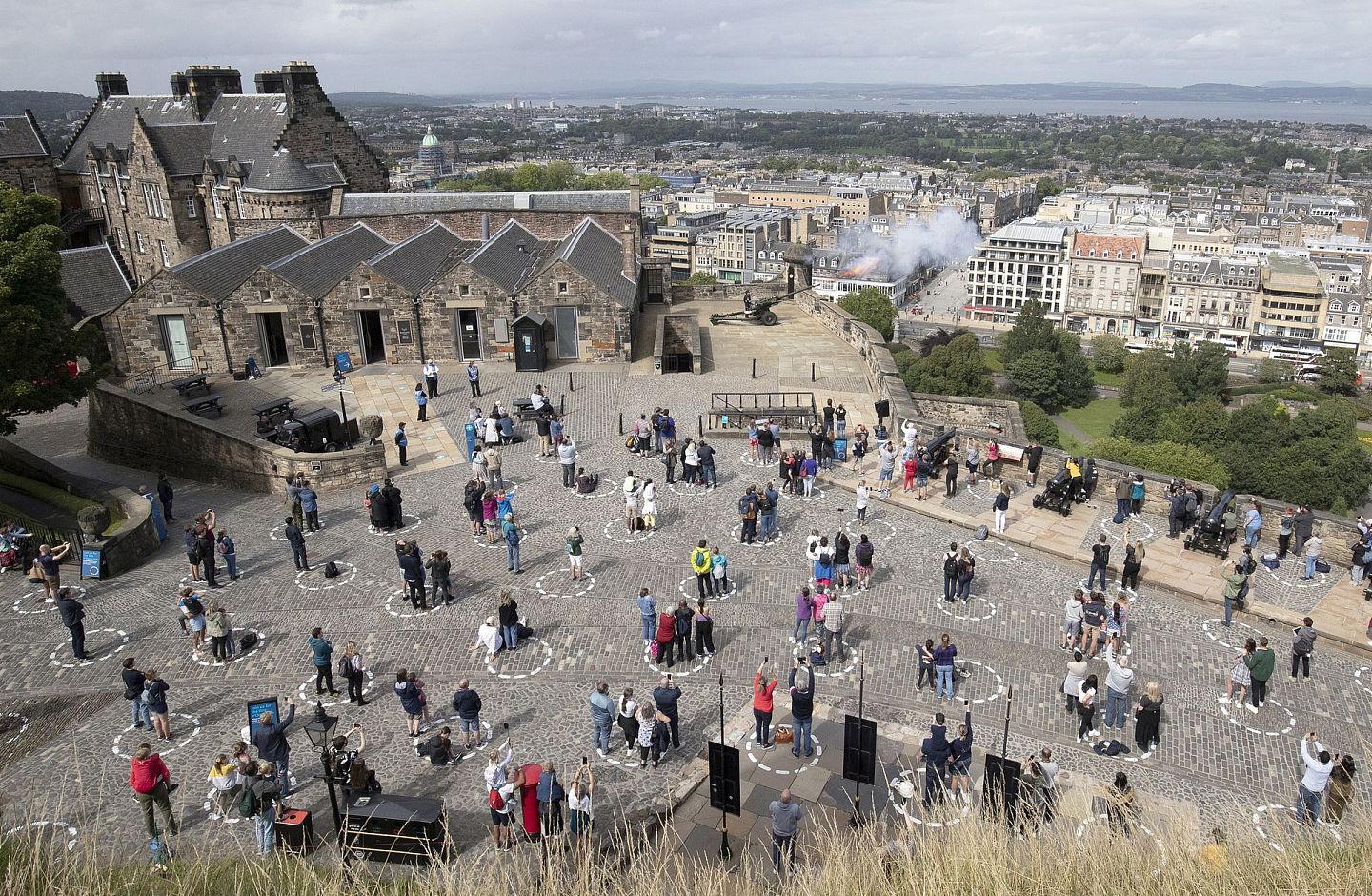 在疫情封锁期间，英国爱丁堡的旅客们站在画好的圆圈中保持社交距离。（视觉中国）
