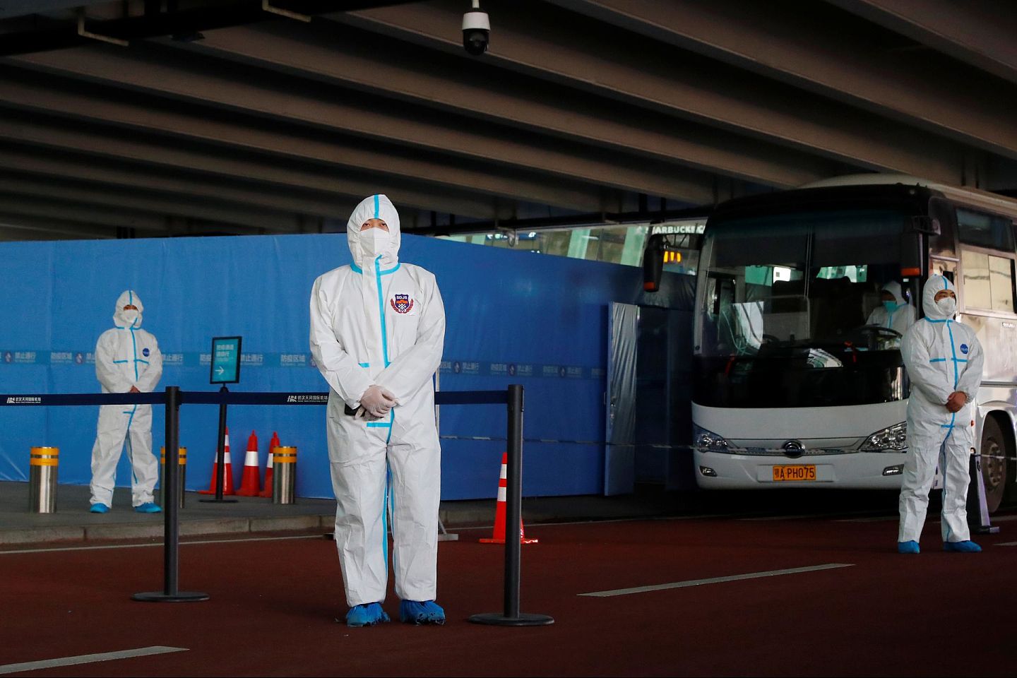 2021年1月14日，身穿防护服的工作人员在湖北省武汉市天河国际机场等待世界卫生组织专家组。（Reuters）