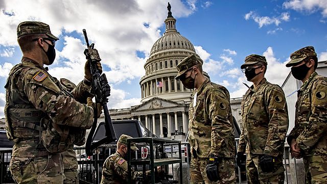 National Guard soldiers are issued their M4 rifles and live ammunition on the east front of the US Capitol - 17 January 2021