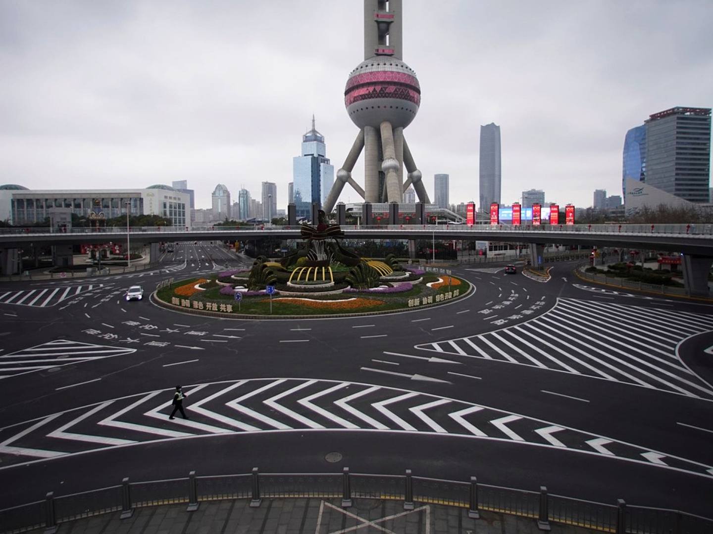 由于新冠肺炎疫情持续蔓延，中国很多城市成为“鬼城”。图为2020年2月5日，上海浦东陆家嘴金融区一名戴着口罩的警察走在东方明珠塔前，路上人烟稀少。（Reuters）
