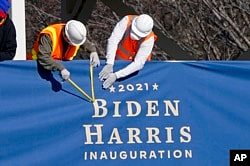 工作人员在白宫前的宾夕法尼亚大道上的就职典礼媒体观礼台安装有“2021拜登哈里斯”字样的横幅。(2021年1月14日)