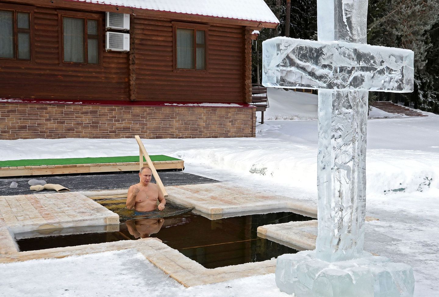 普京步入一个十字形水池，在一个冰十字架前进行洗礼仪式。（Reuters）