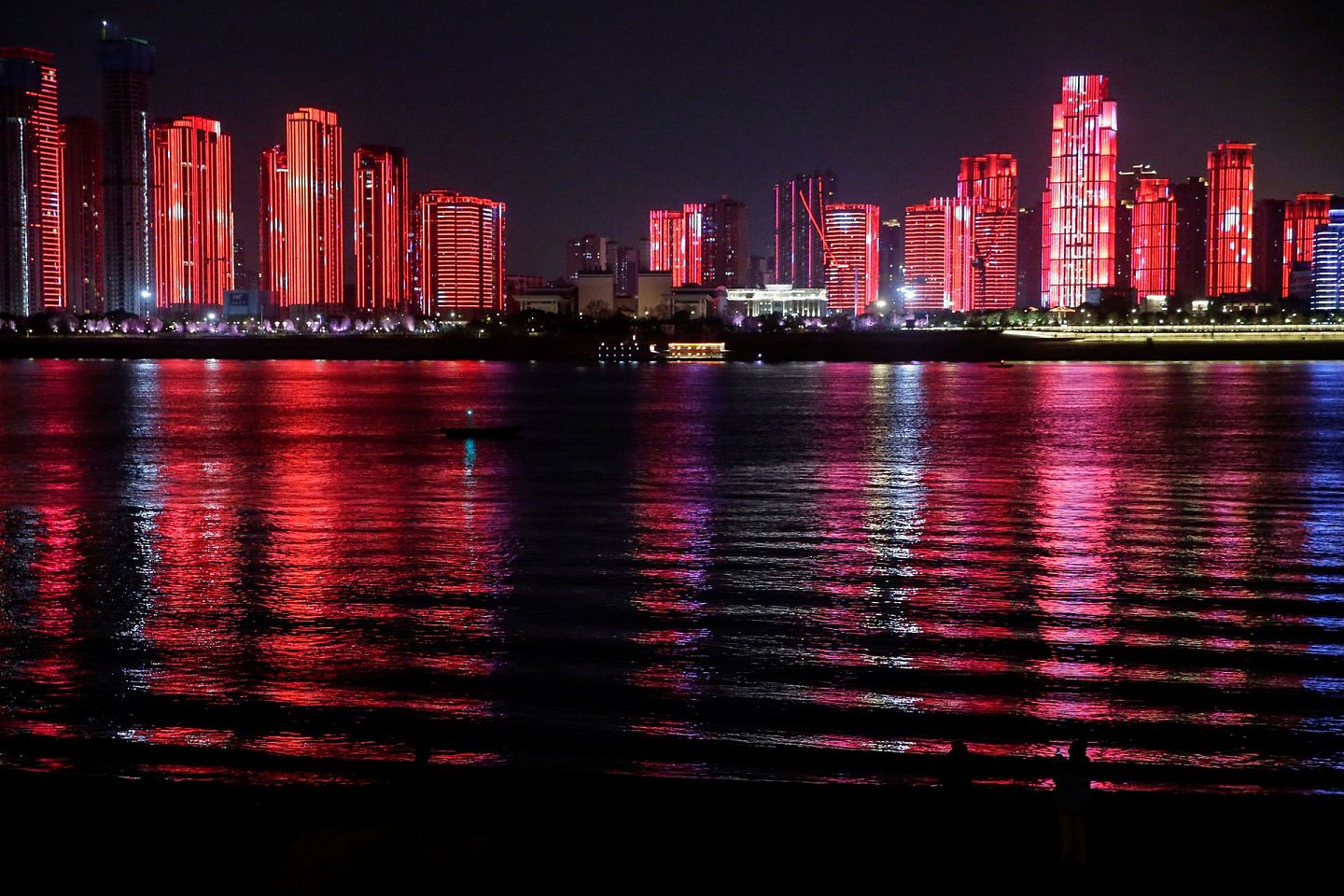 2020年12月31日，在曾经的疫情爆发中心，中国武汉迎接新年的到来，长江边举行了盛大的灯光秀，长江边的楼群呈现出一片中国红的绚丽景象。（Reuters）