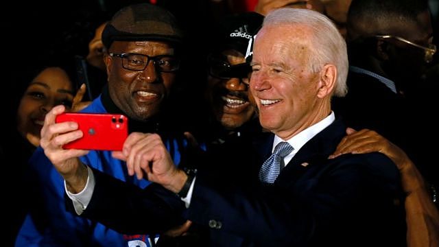 Joe Biden takes a selfie with two voters.