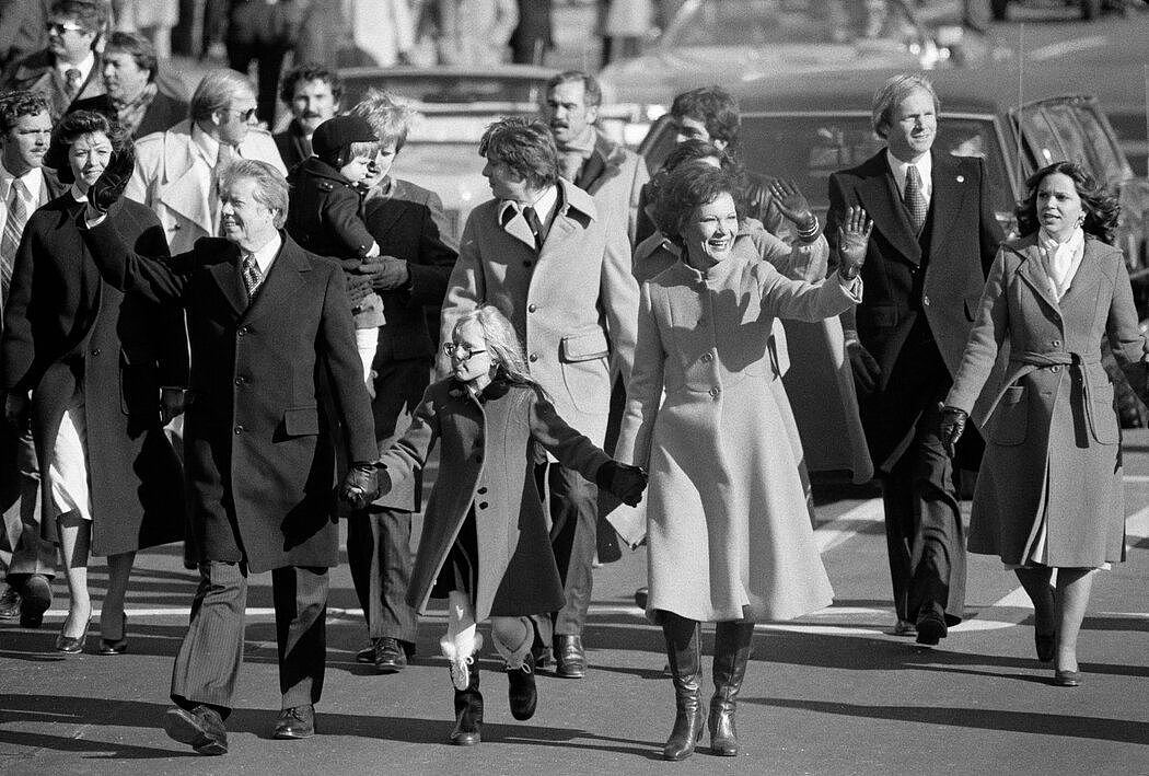 1977年，在总统就职游行中，吉米和罗莎琳·卡特牵着女儿艾米的手走在宾夕法尼亚大道上。
