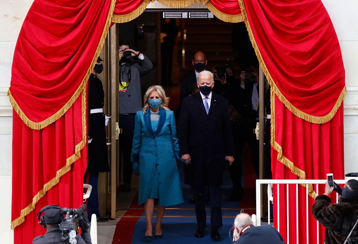 拜登携妻子吉尔（Jill Biden）的手，步出门廊，预备宣誓就职。（Reuters）
