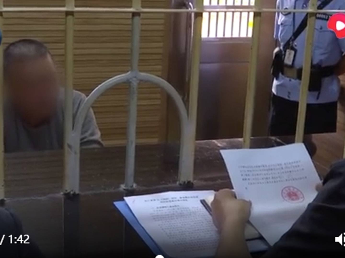 云南高院人员给孙小果念再审决定书。（中国央视新闻截图）