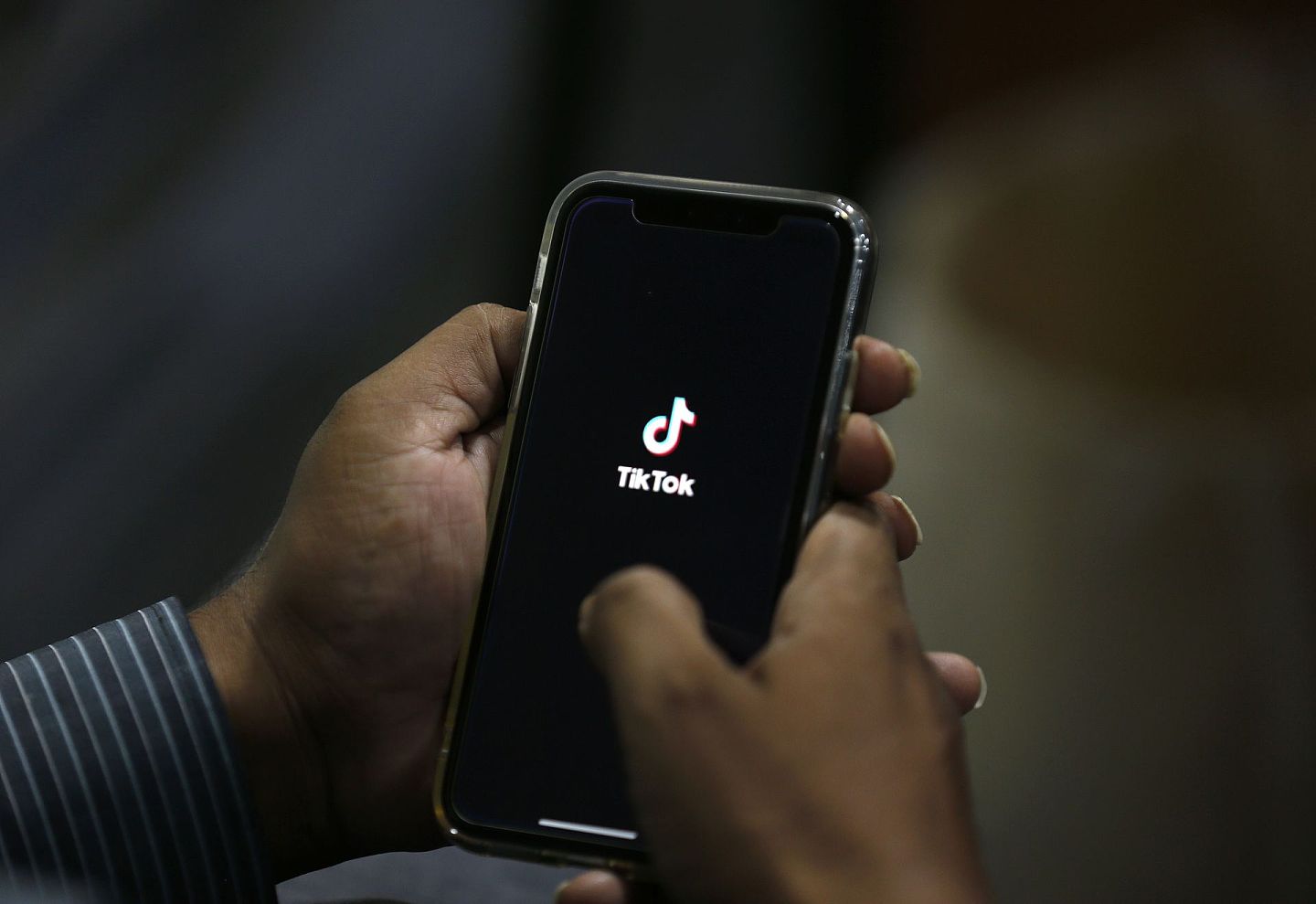 美国“封杀”TikTok：图为7月21日，巴基斯坦一名男子在手机打开TikTok应用程式。（AP）
