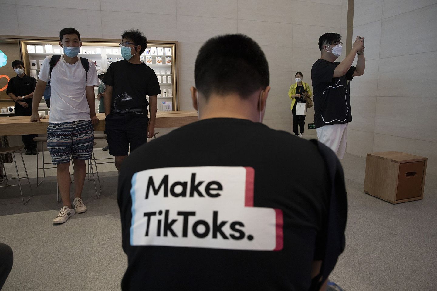 美国“封杀”TikTok：图为7月17日一名男子穿上宣传TikTok字句的汗衫，坐在位于北京的苹果公司门市内。