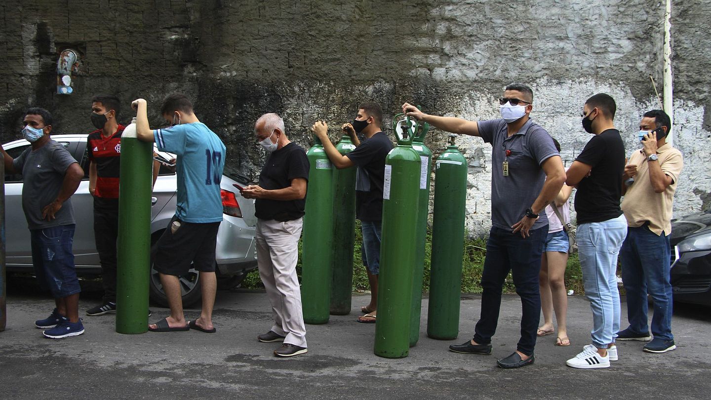 1月15日，在巴西亚马逊州首府马瑙斯，新冠肺炎患者的家属带着空的氧气樽在供应商门外排队，等候购买患者所需的氧气。（AP）
