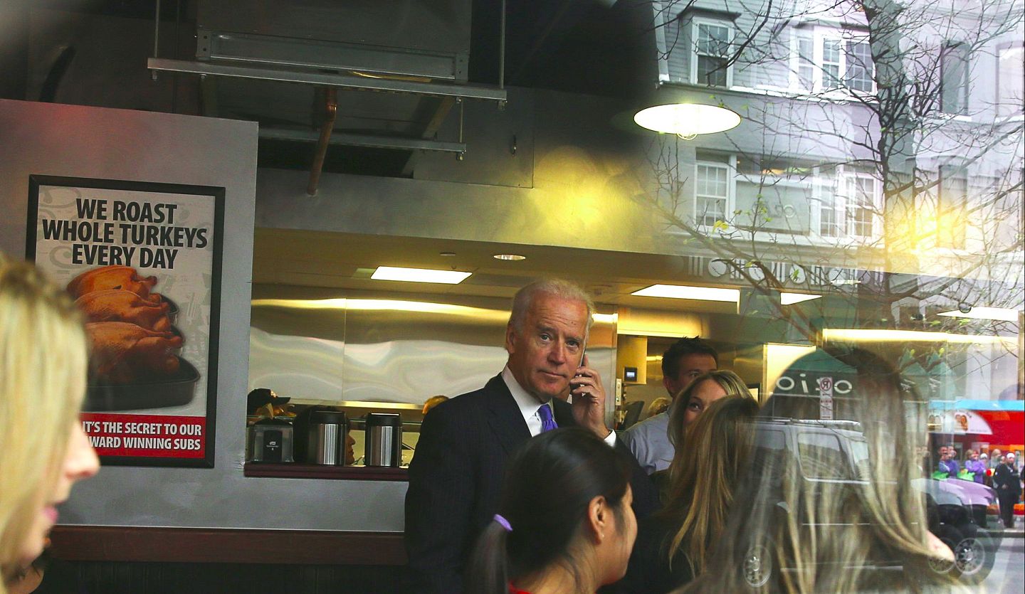 图为拜登2013年11月21日在华盛顿一间餐厅打电话。（Getty）