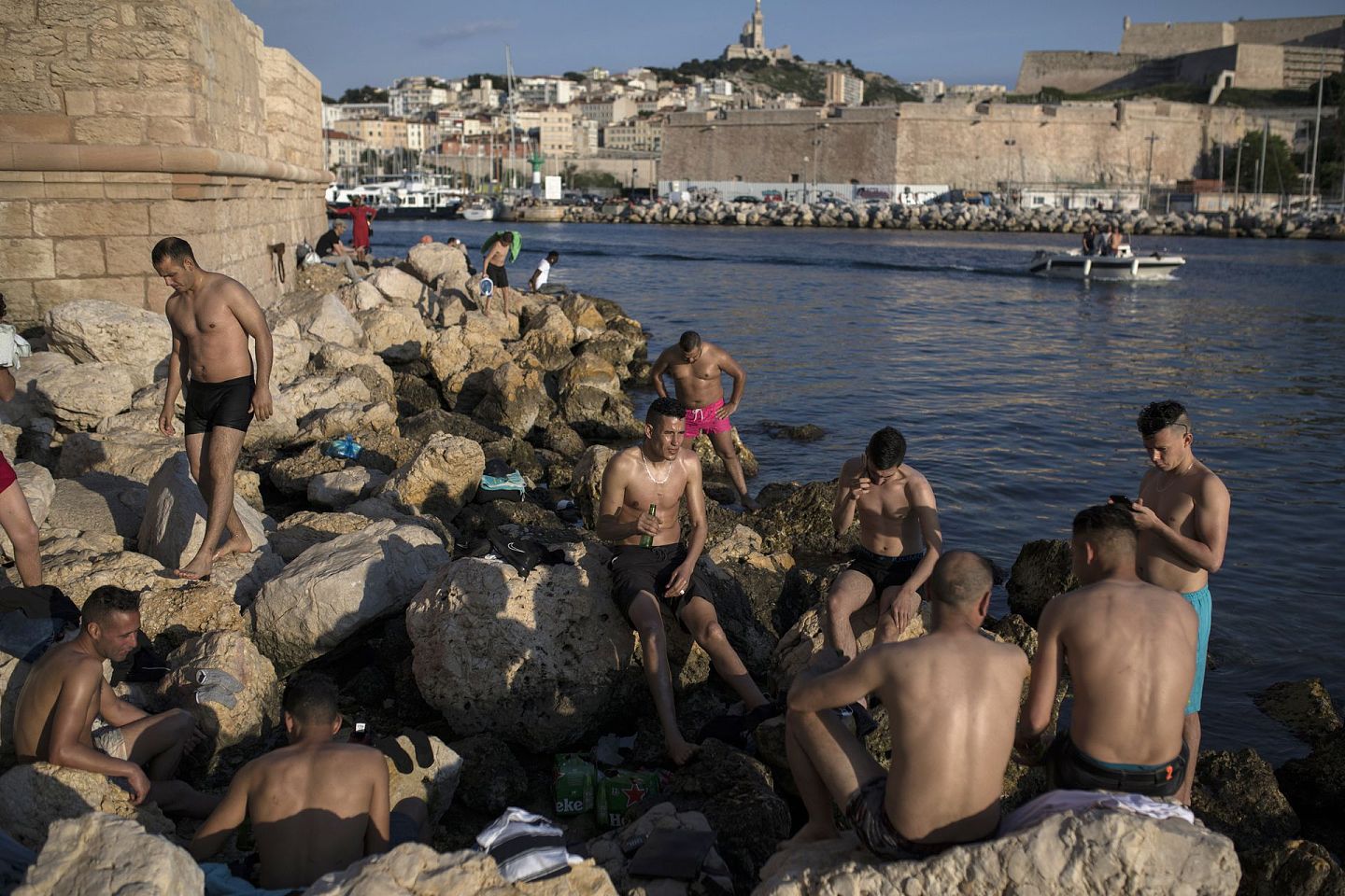 法国民众不顾疫情，在海边休闲。图为2020年5月26日，法国南部马赛老港口入口处，日光浴者在享受夕阳。（AP）