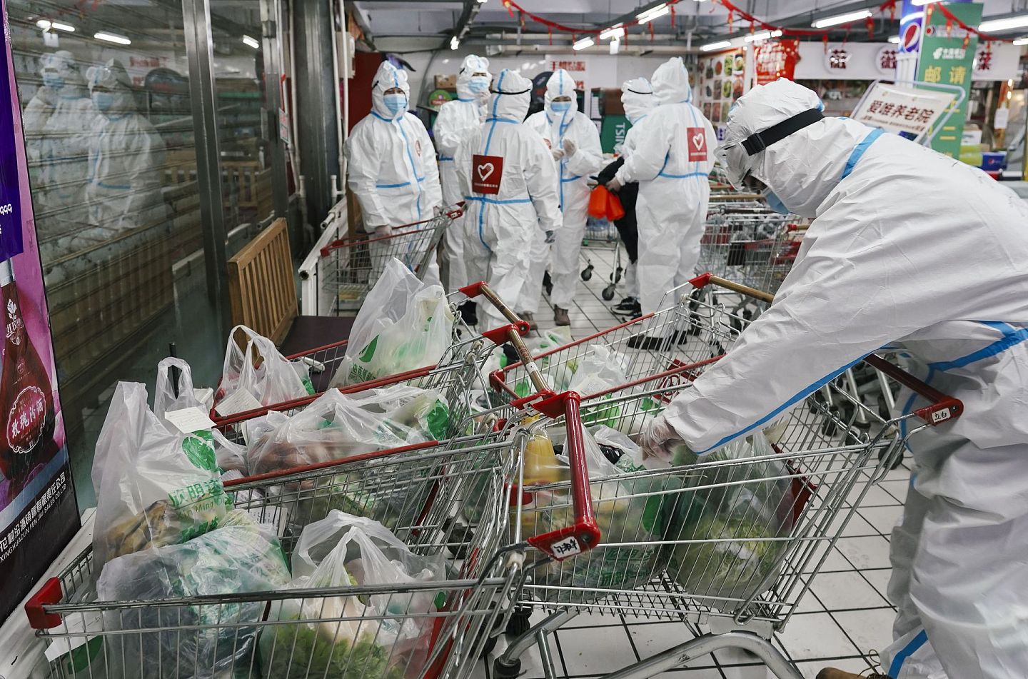 吉林通化因封城，民众的生活物资一度受到影响。图为 1月24日，在通化市东昌区一家连锁超市，进行生活物资配送的志愿者根据订单核对商品。（新华社）