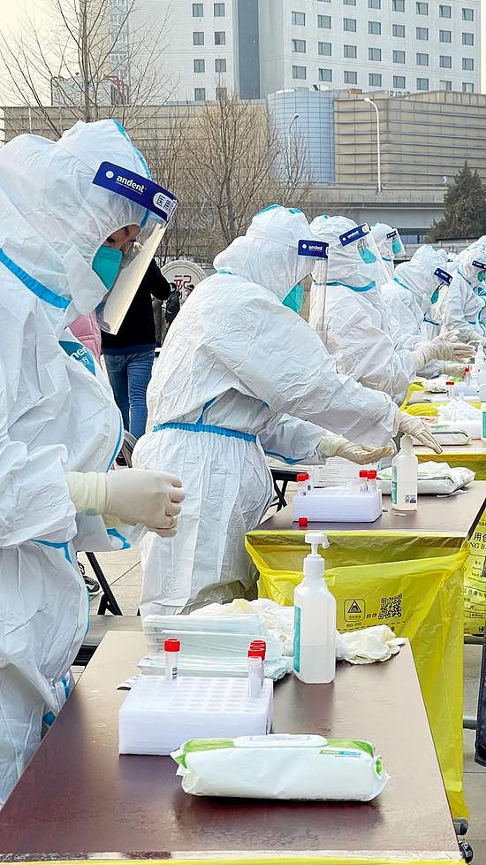 1月22日，在北京 西城区展览馆前广场的核酸采样点，医务人员为采集核酸样本做准备。