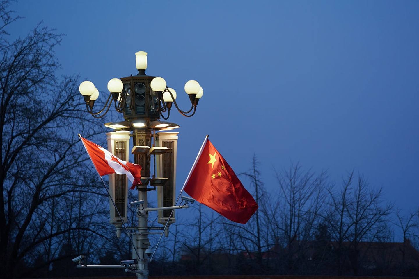 图为2017年12月4日，中国与加拿大的国旗悬挂在北京紫禁城前面。 （Getty）