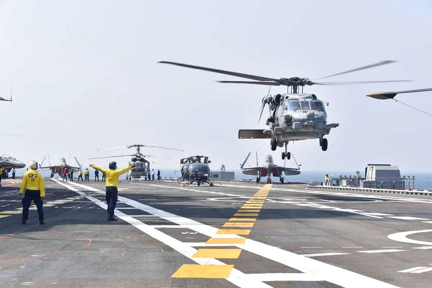 在军演现场，直升机降落在航空母舰的甲板上。（AP）