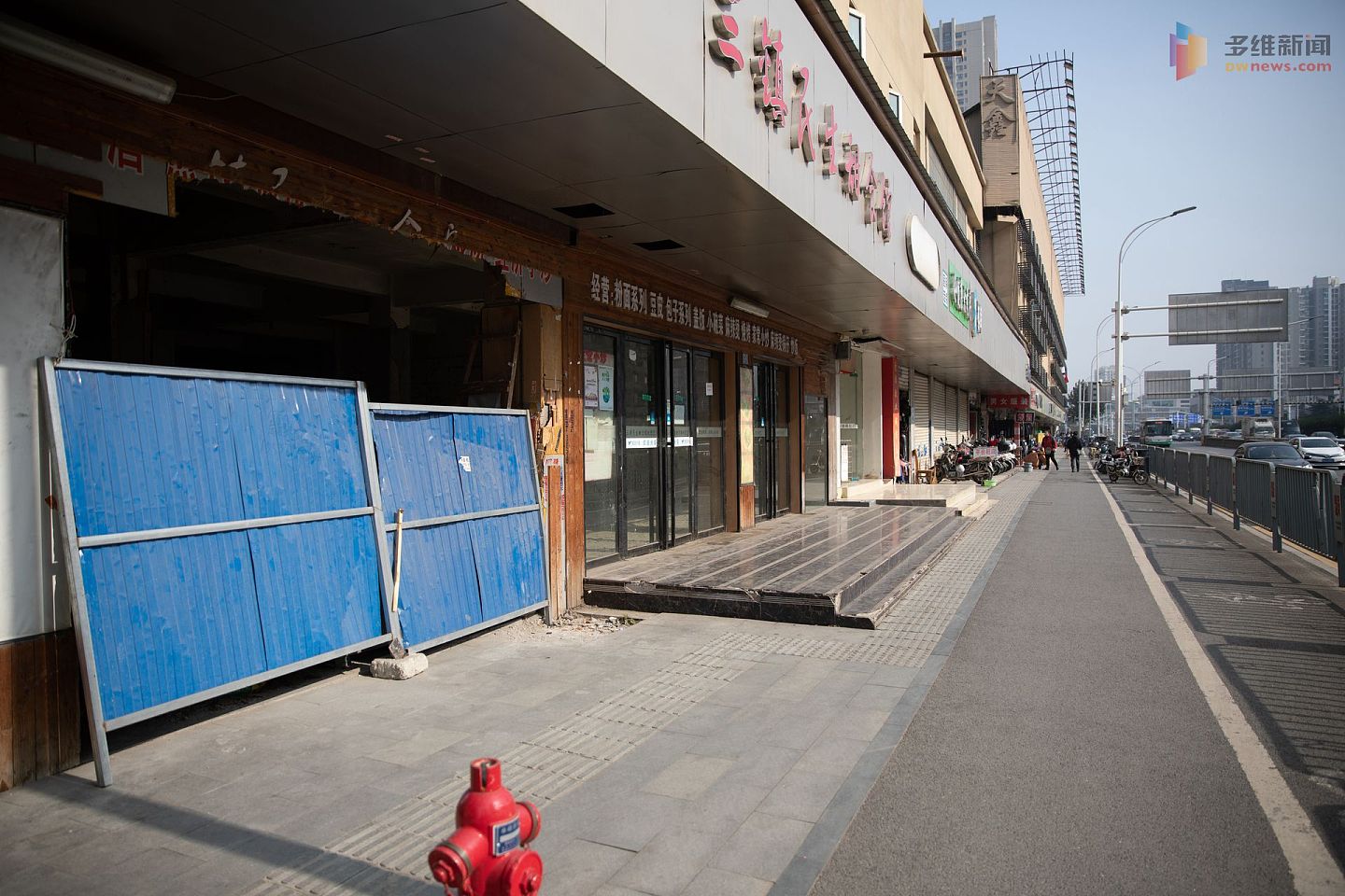 武汉的华南海鲜市场成为武汉疫情传播的一个关键地点。在封闭后，这里经过多轮消杀，现已重新开放二层的眼镜市场。图为华南海鲜市场临街店铺前的人流显得有些冷清。（多维新闻）