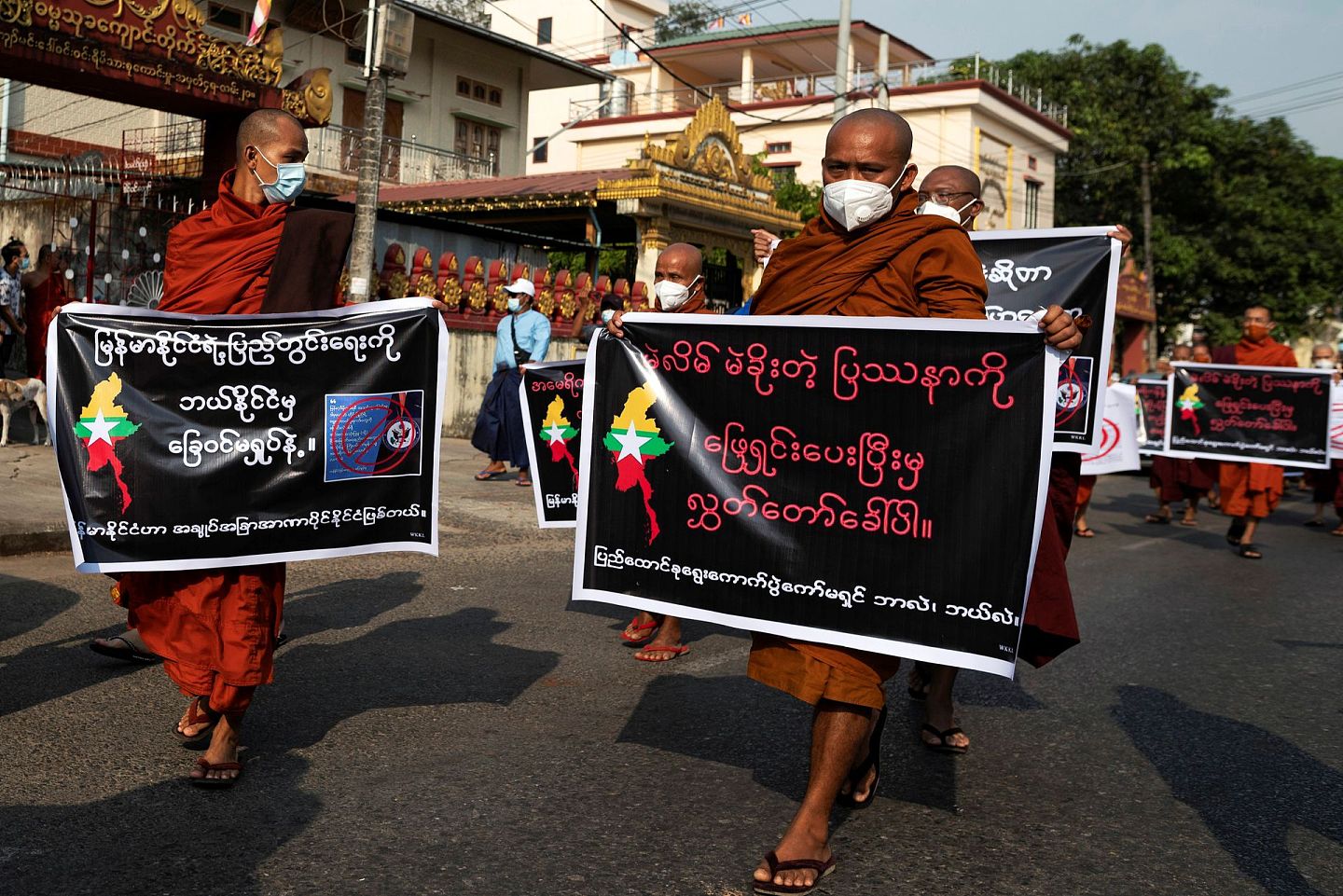 缅甸僧侣手举条幅，在街上游行。（Reuters）