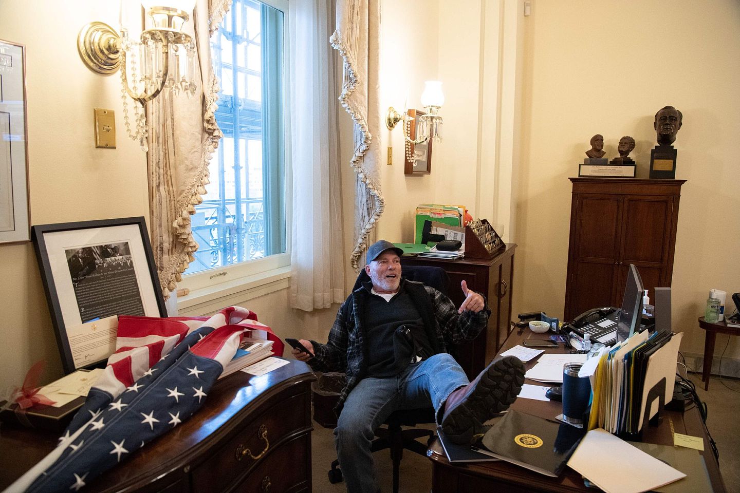 2021年1月6日，华盛顿特区，美国总统唐纳德·特朗普的支持者理查德·巴尼特坐在美国众议院议长南希·佩洛西的办公室里进行抗议。（AFP）