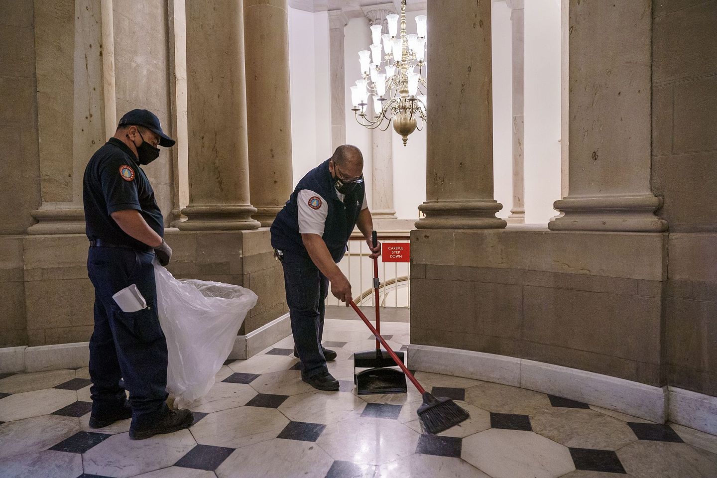 2021年1月7日，在效忠特朗普的暴力抗议者袭击美国国会后，工人们在清理众议院议长佩洛西办公室外的碎片。（AP）