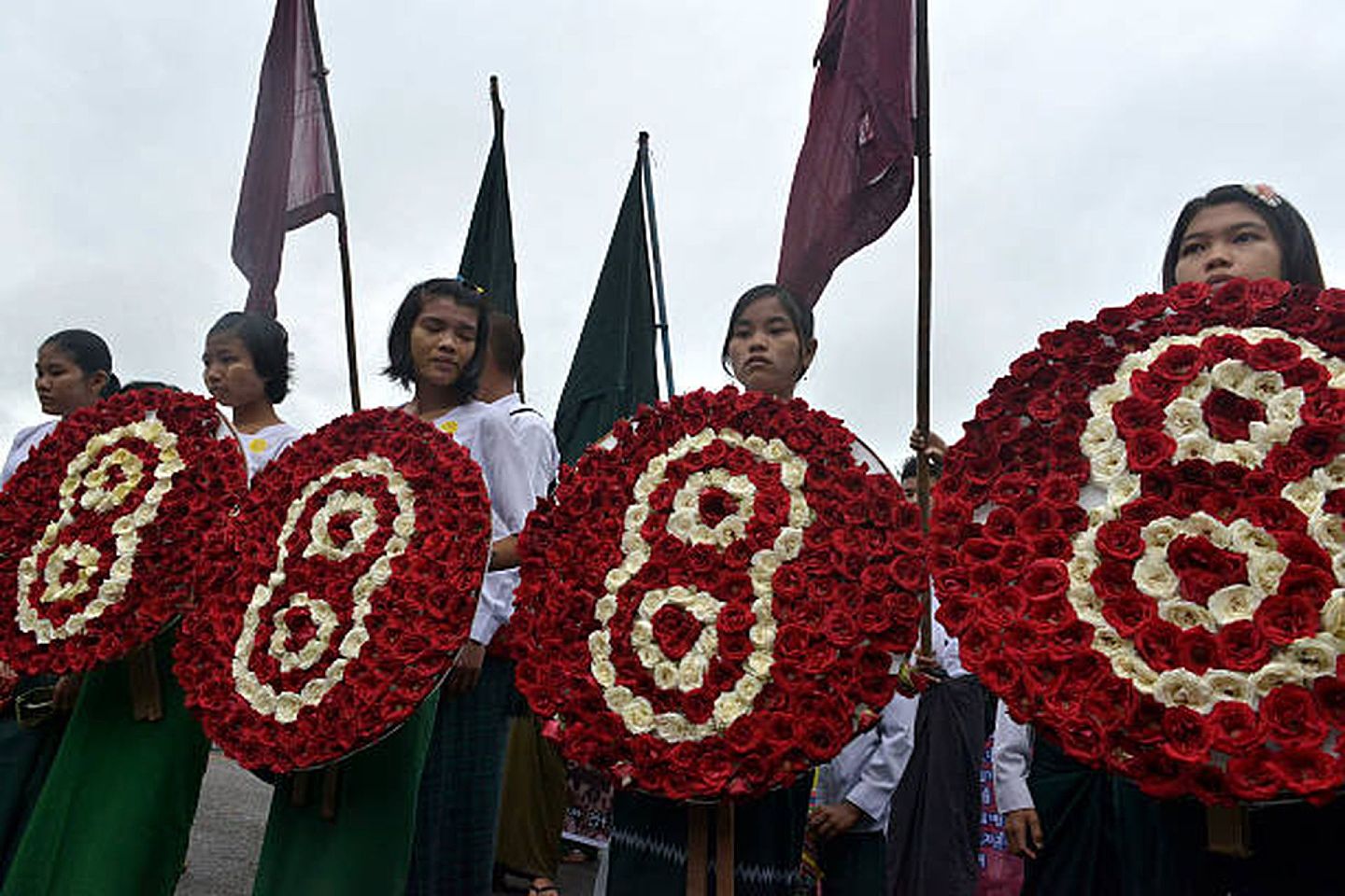 2013年8月8日，缅甸仰光，学生们在庆祝“8888民主运动”25周年的游行中手持数字8的花圈。（Getty）