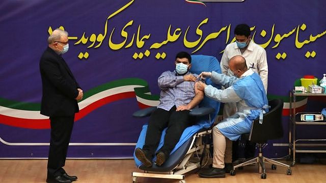 伊朗卫生部长萨伊德·纳玛琪（Saeed Namaki 左）陪儿子帕尔萨（Parsa）接种第一剂卫星五号疫苗。