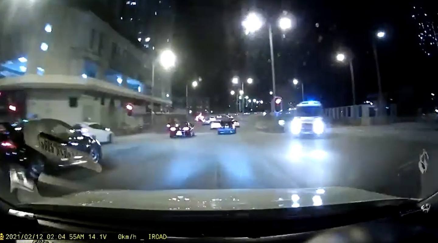 凌晨2时04分，车队前行时，交通灯仍是红灯。 当时有一辆警车在对面线亮起蓝灯，惟车队并无理会，继续冲灯前行。 （网民Michael Ming片段）
