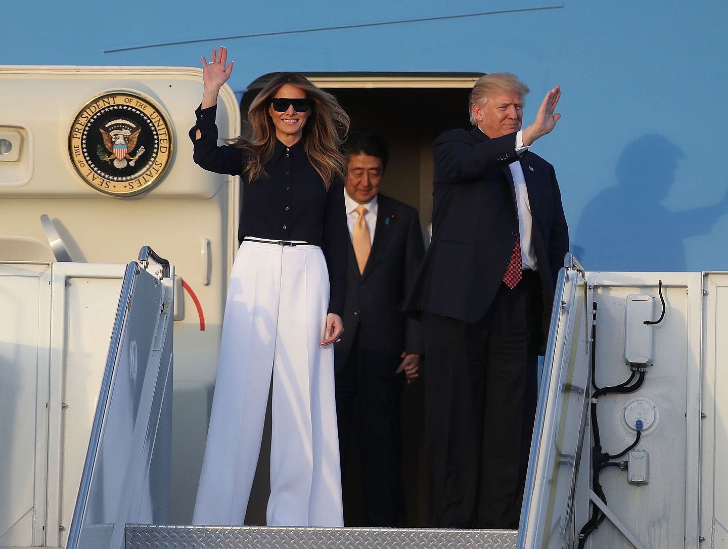 2017年2月10日，特朗普和梅拉尼娅以及日本首相安倍晋三抵达棕榈滩国际机场。梅拉尼娅这身装扮跟1973年积琪莲抵达同一机场的打扮相似。（Getty）